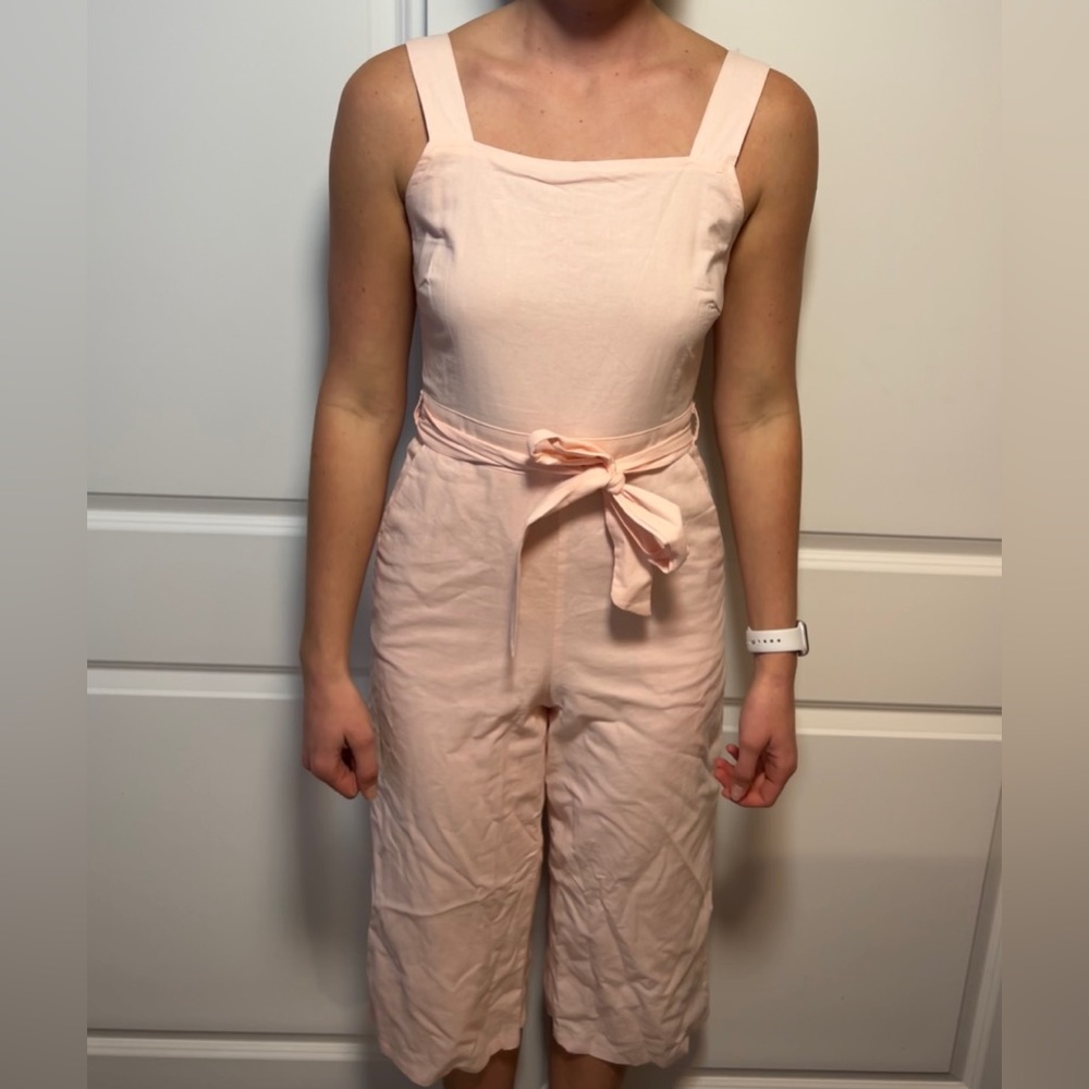Baby pink jumpsuit goes just past the knees